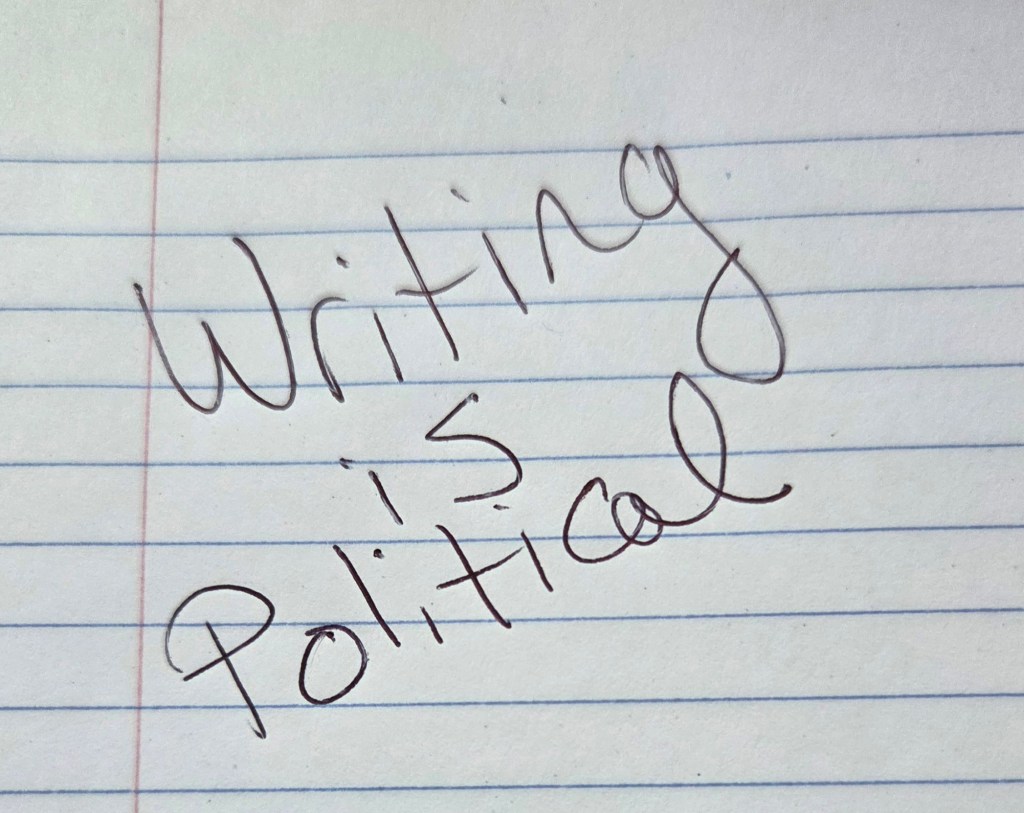 phrase "Writing is political" on lined paper