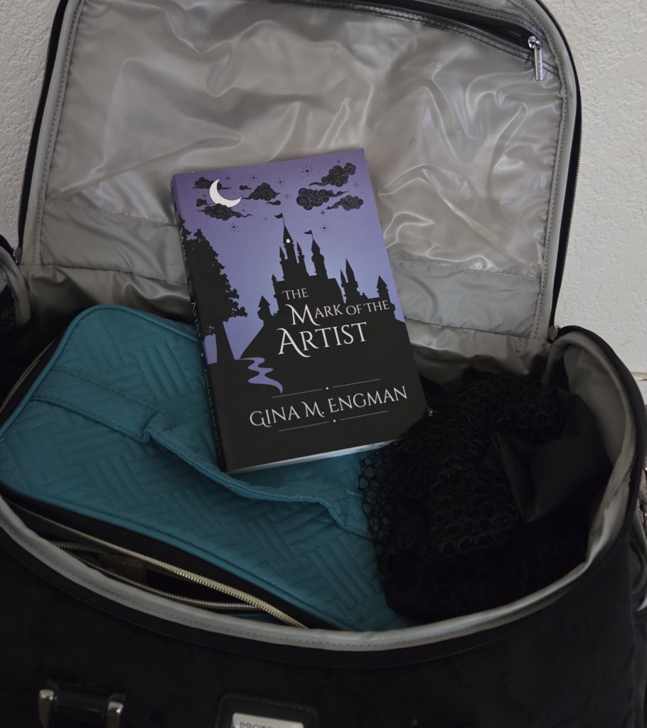 The novel The Mark of the Artist sitting in a travel bag